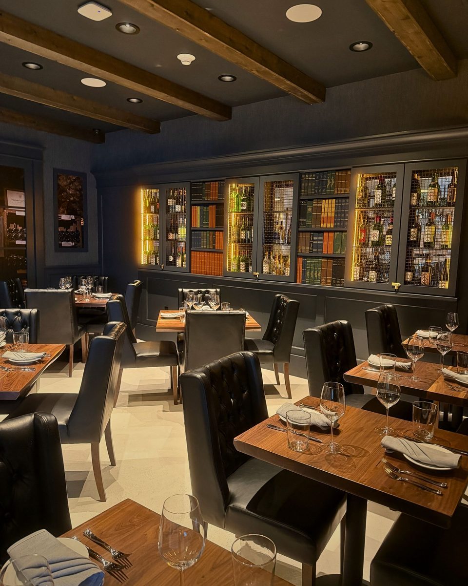 The warmly lit dining room at Enology Wine Bar & Bistro in Saint James, New York