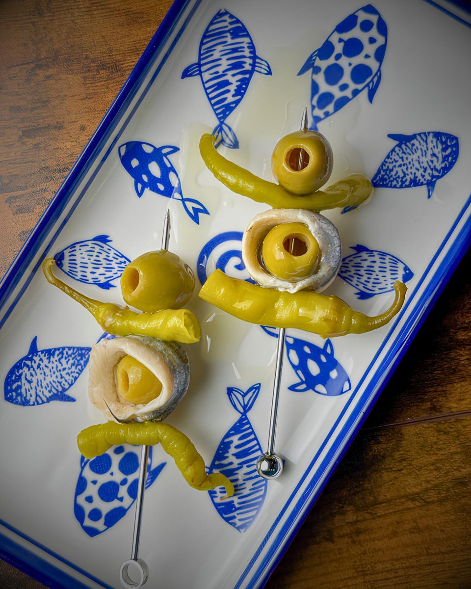 Gildas of olives, anchovy, and guindilla peppers on a blue fish-patterned plate