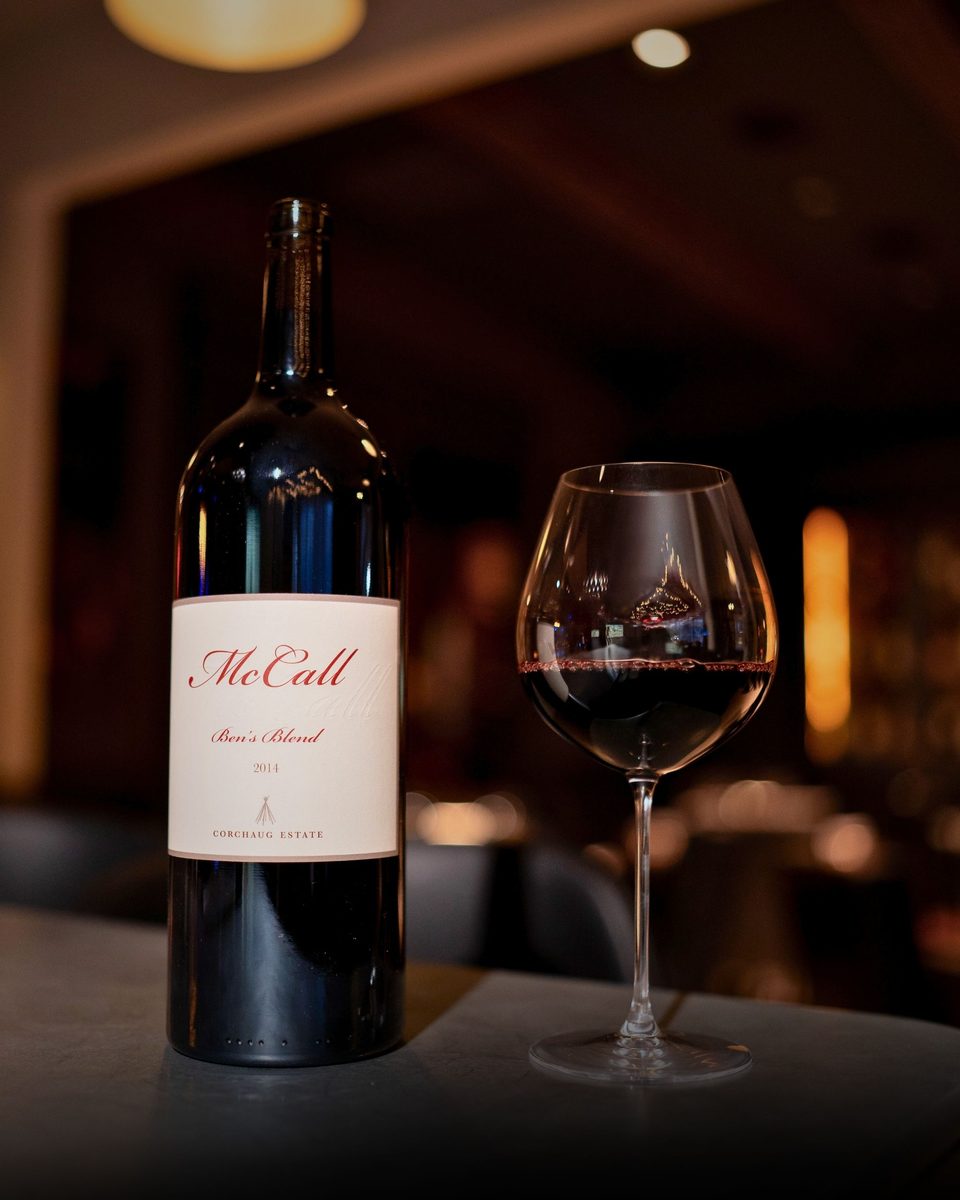 A bottle of McCall Ben's Blend with a glass of red