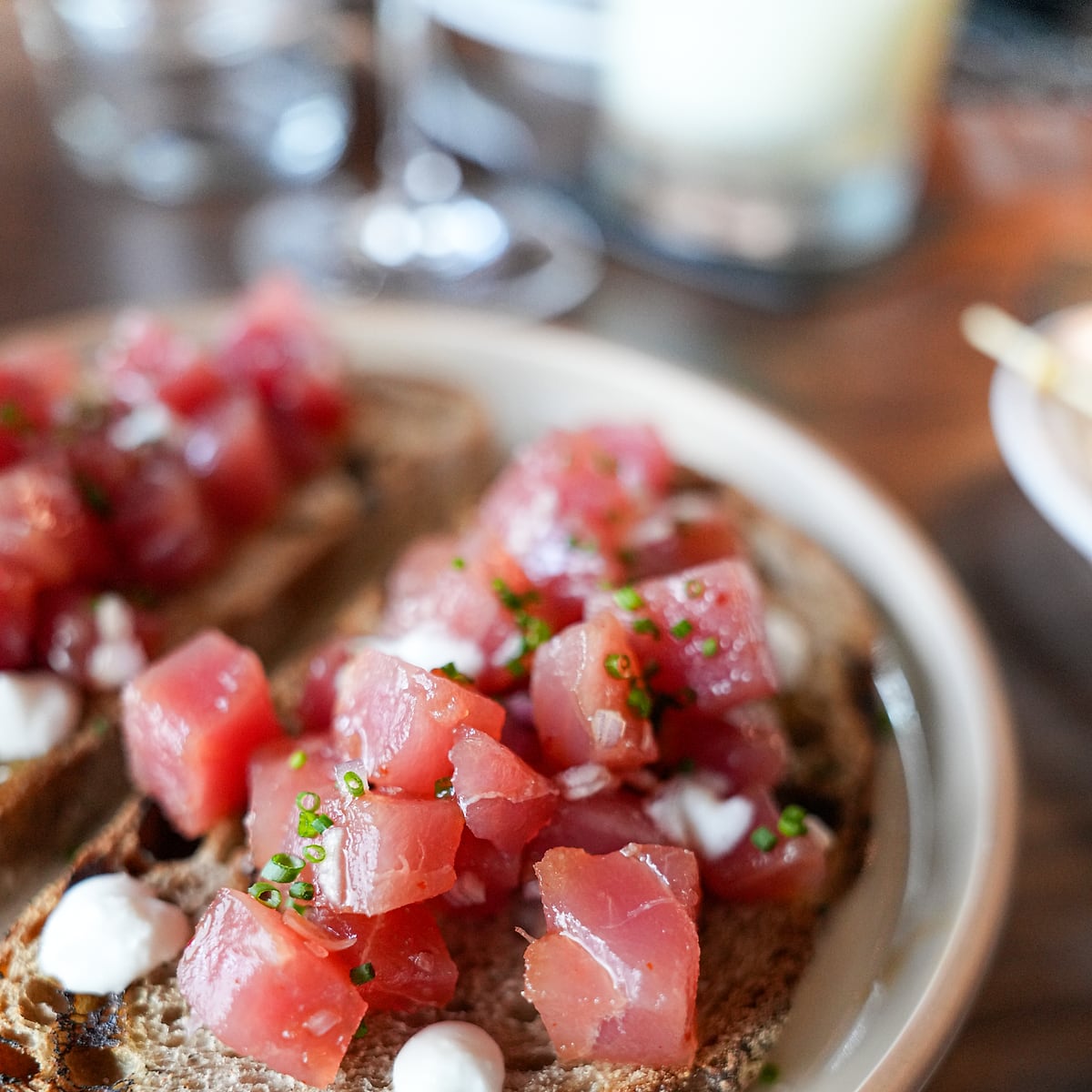 Tuna tartare with feta and chives piled on grilled sourdough