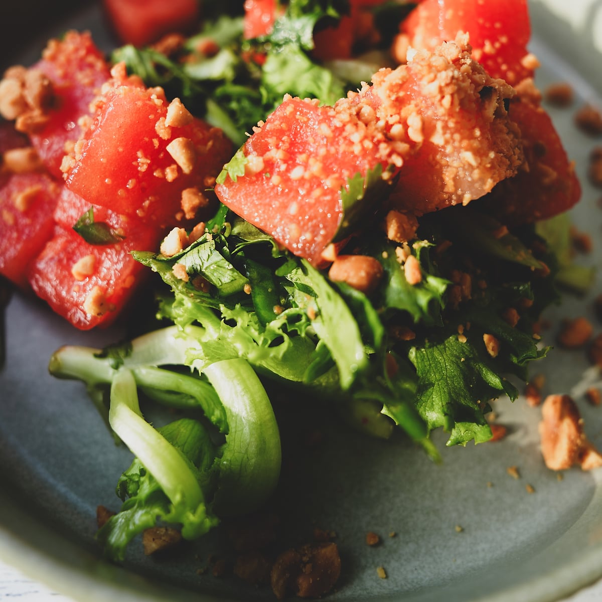 Watermelon salad with frisee, crushed pistachio, and herbs
